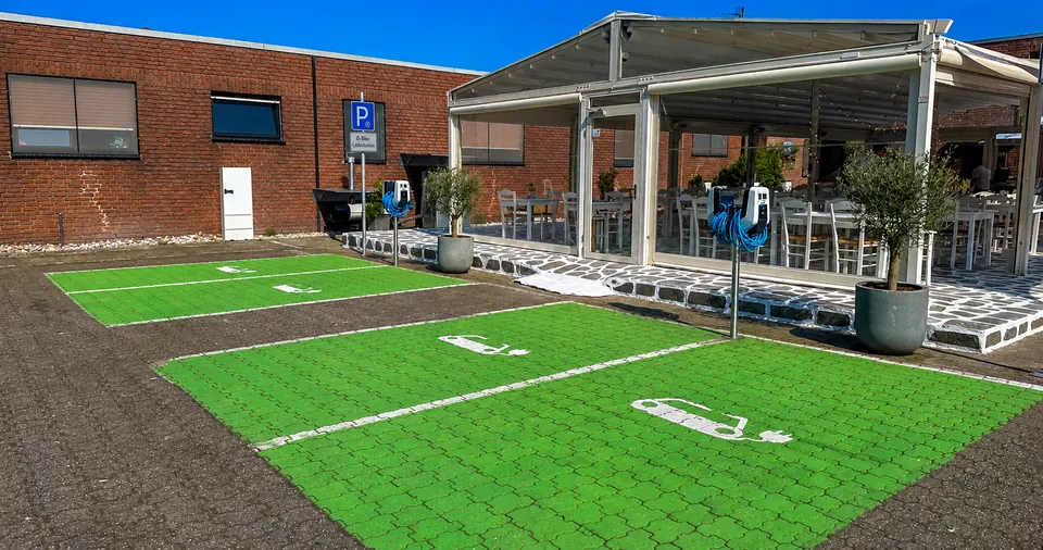 E-Auto-Ladestationen mit grünen Stellplätzen an der Terrasse des Hotel Omega in Moers