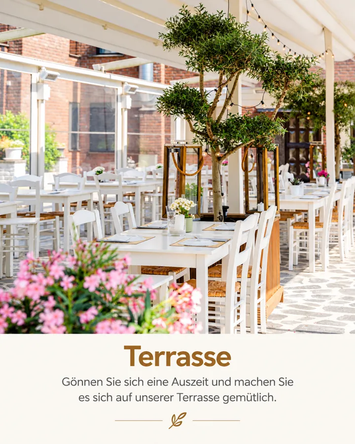 Überdachte Terrasse mit weißen Tischen, Olivenbäumen und Blumen im Hotel Omega